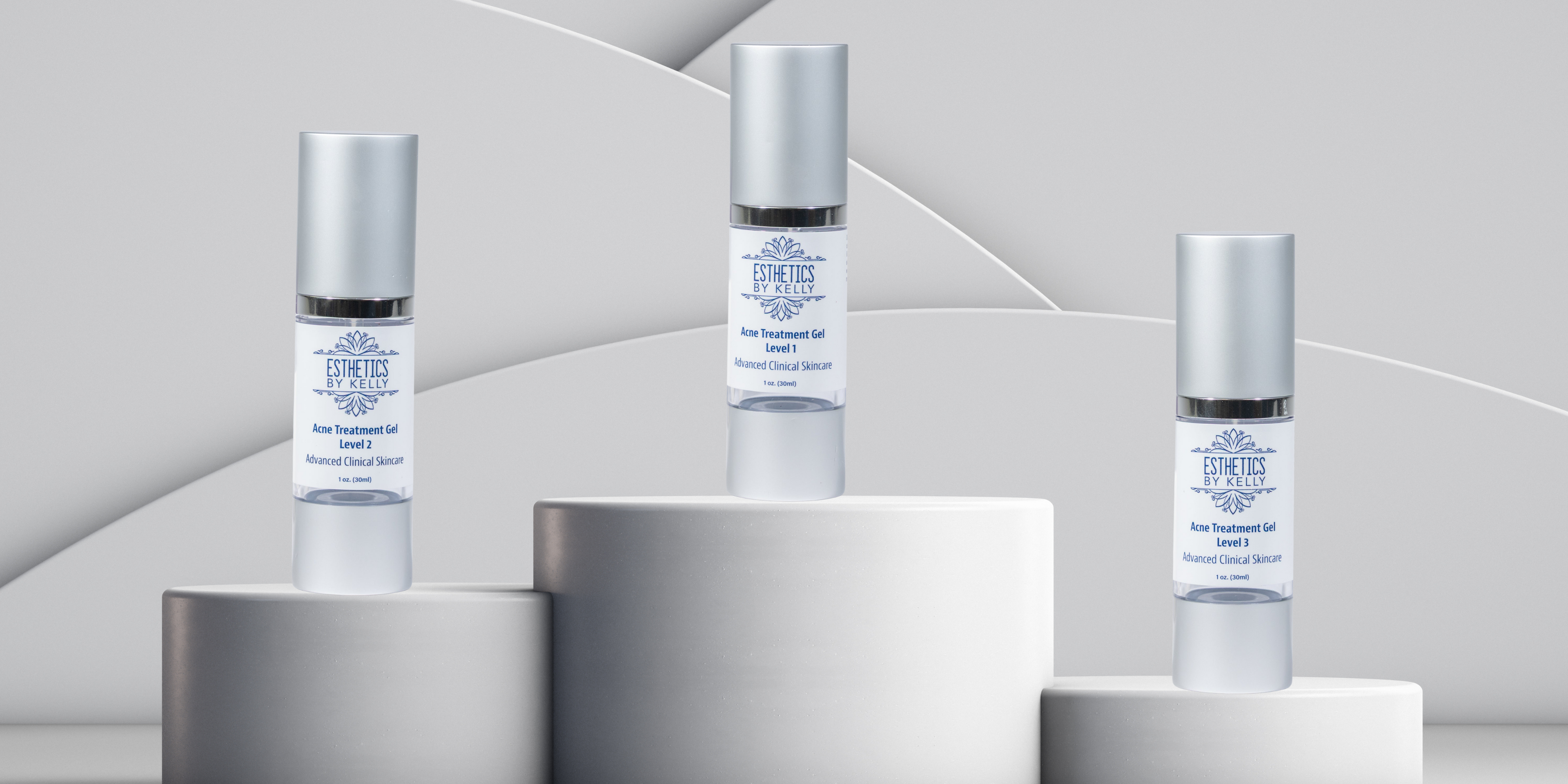 Three skincare bottles on cylindrical stands against a light gray background. Depicts the 3 step acne line. 