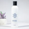 Calm Gel Cleanser skincare bottle for sensitive and acne-prone skin, with plant decor.