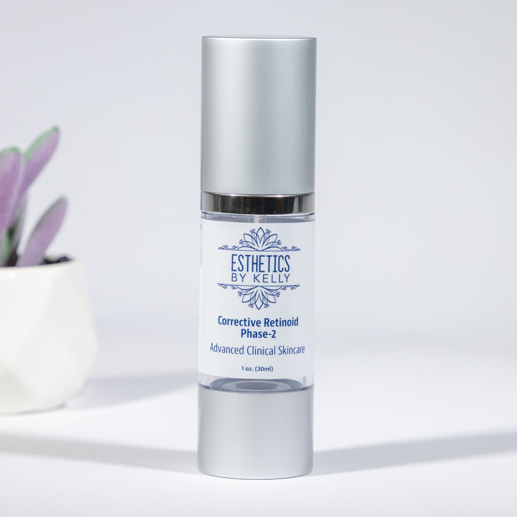 Skincare bottle labeled 'Esthetics by kelly' with a small potted plant on a light background